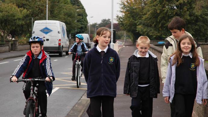 Children in school uniform walking and cycling 