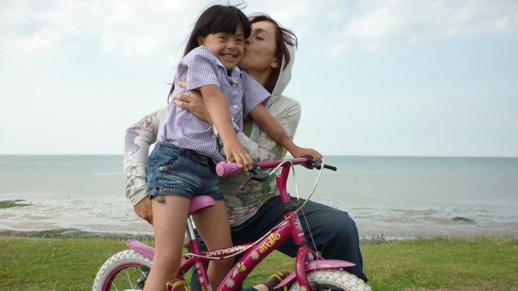 Mum hugging daughter on pink bike