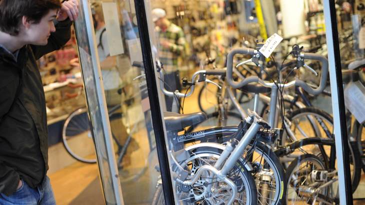 Man looking at Brompton bikes in shop window