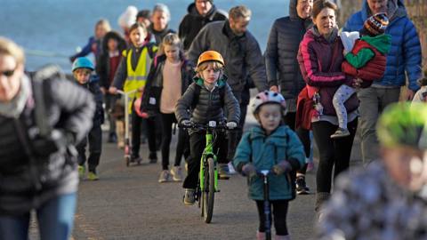 People cycling, walking and scooting to school