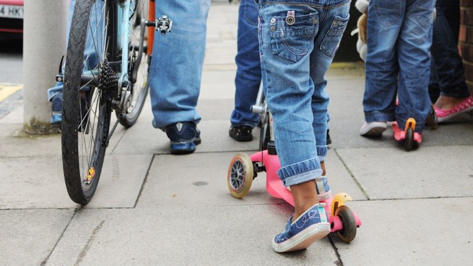 Adults and children walking and scooting 