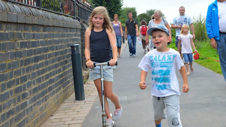 children and families walking and scooting on pavement