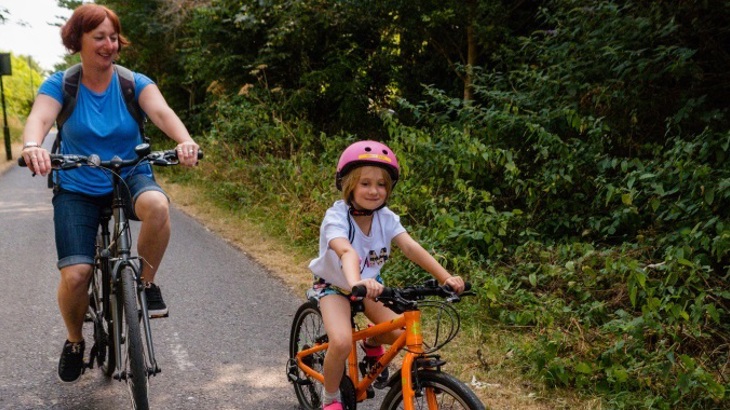 Mum riding bike with daughter on traffic-free path