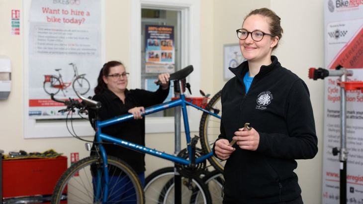 women repairing bikes in active travel hub in Scotland