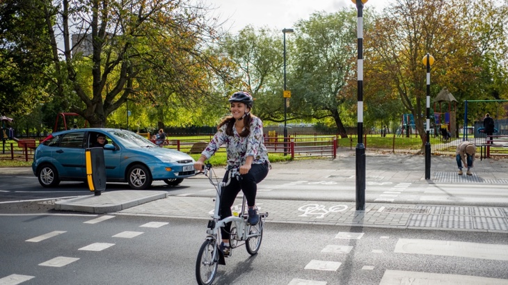 Woman cycling over a road crossing in London