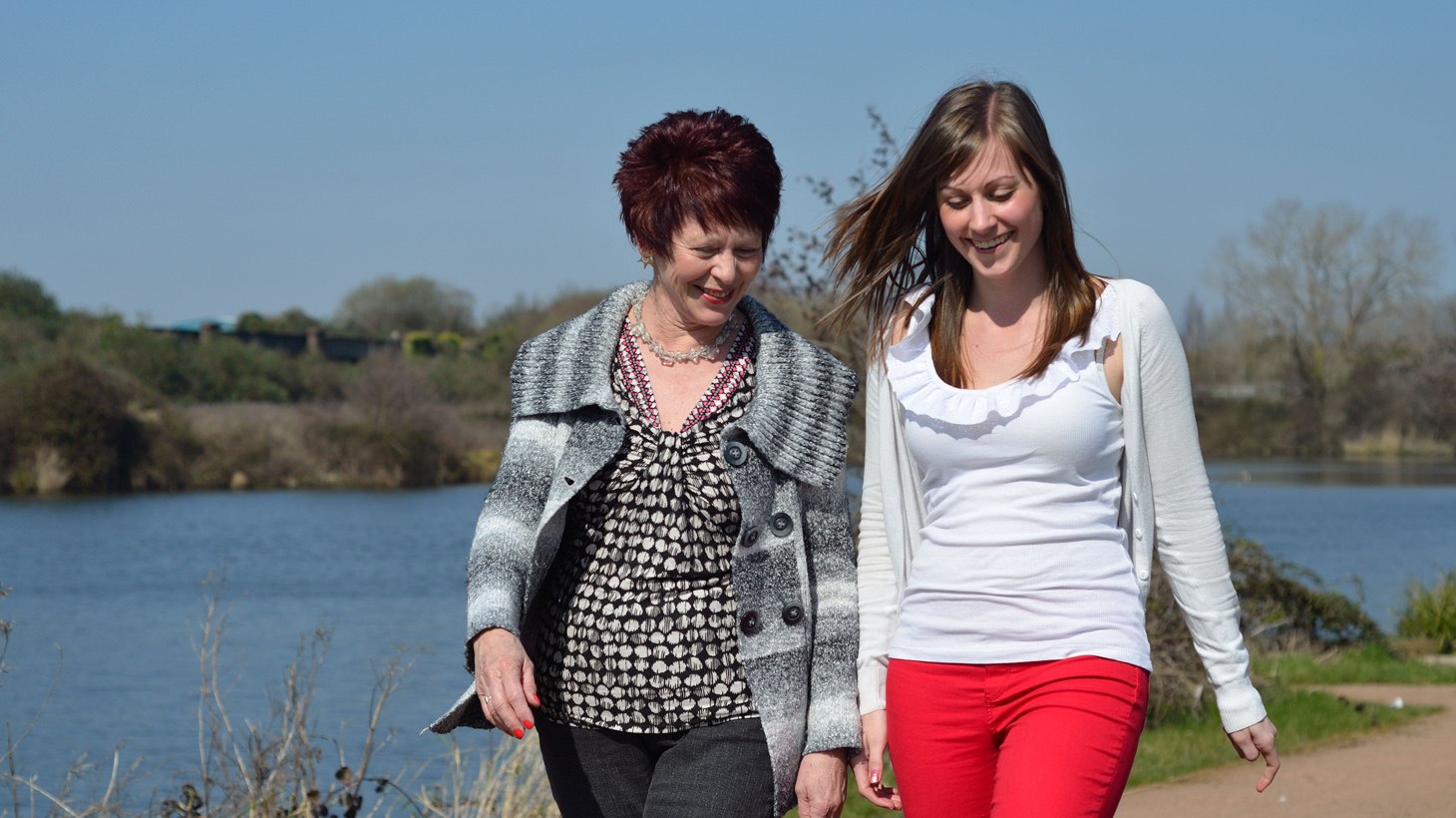Two women walking on a traffic free path next to water