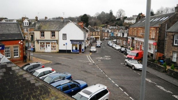 Town centre in Scottish town with many parked cars