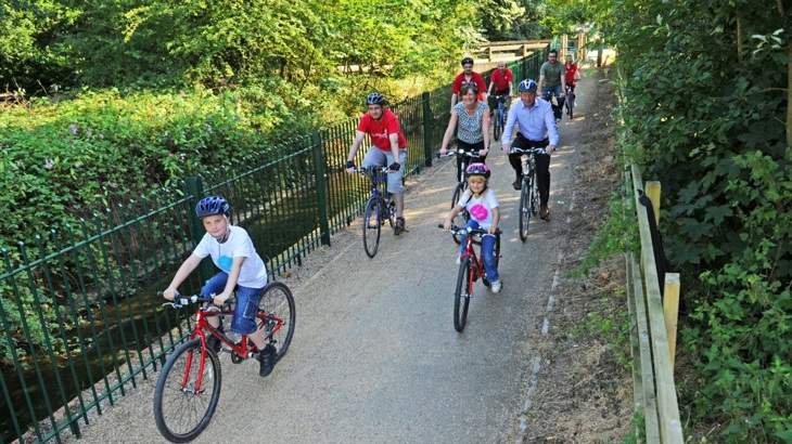 adults and children cycling on bridge
