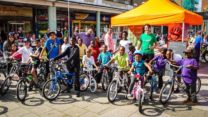 Children on bikes outside of a Walk Wheel Cycle Trust stand in London