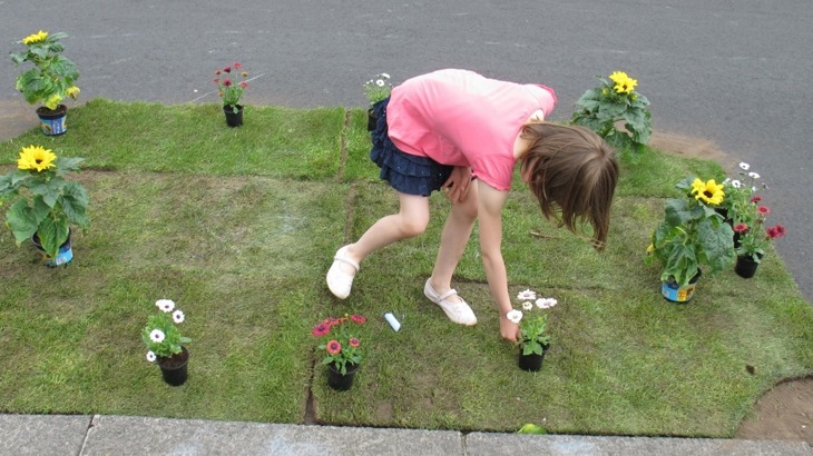 A Young Girl Plants Some Flowers On Embleton Road