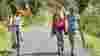 Cyclist passing two walkers on cycle path, both parties waving to each other