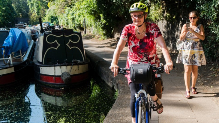 Woman cycling on canal towpath