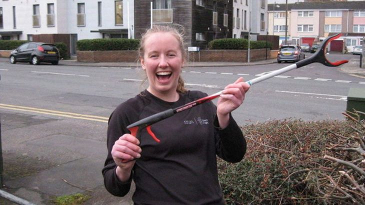 Person in running kit brandishing litter picking tool