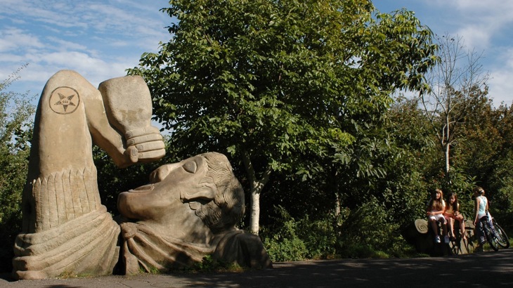 Stone drinking fountain sculpture in shape of Roman centurion with bottle