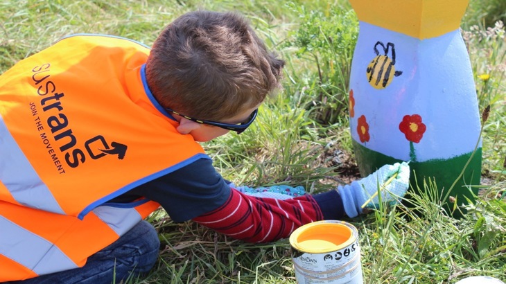 boy painting milepost