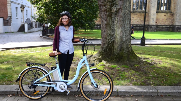 A woman poses with an e-bike