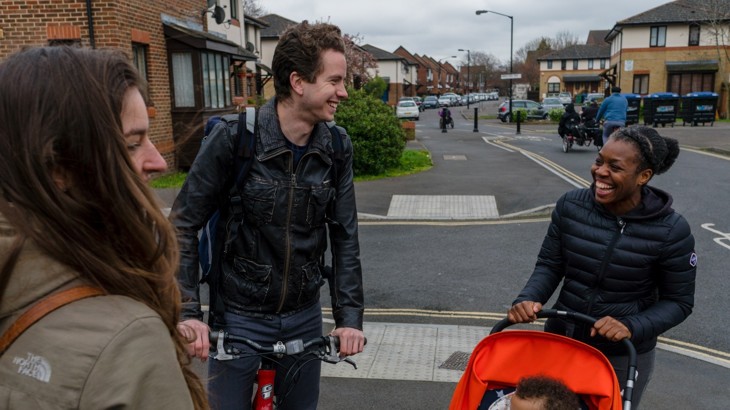 A group of people chatting and smiling in a residential area of London 