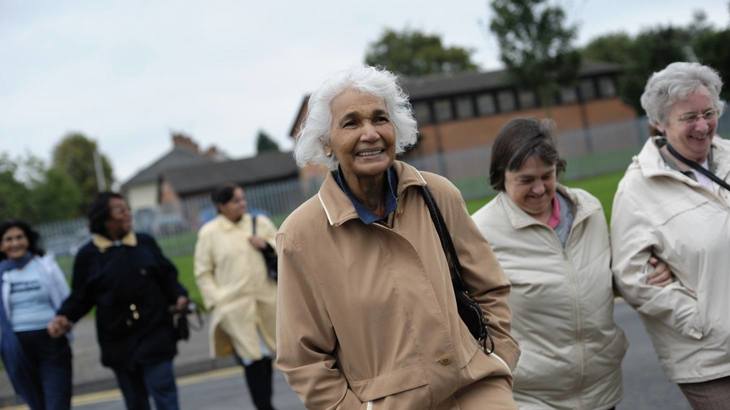 A group of older people walking and smiling together
