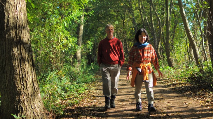 Two People Walk Through Woodlands 