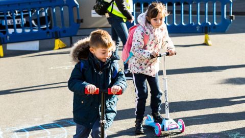Two children playing outside on their scooters during a School Streets closure in Southampton