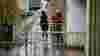 Person on foot with umbrella trying to squeeze past someone on a bicycle through a restrictive barrier on the route