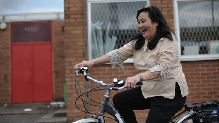 Lady riding a bike and laughing