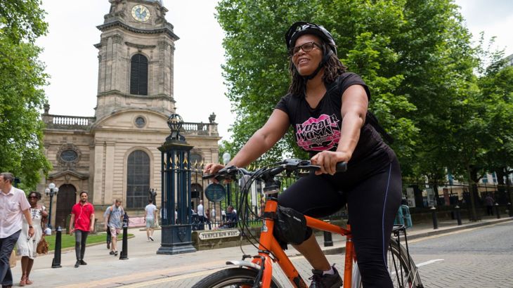 Lady casually cycling in the city with helmet