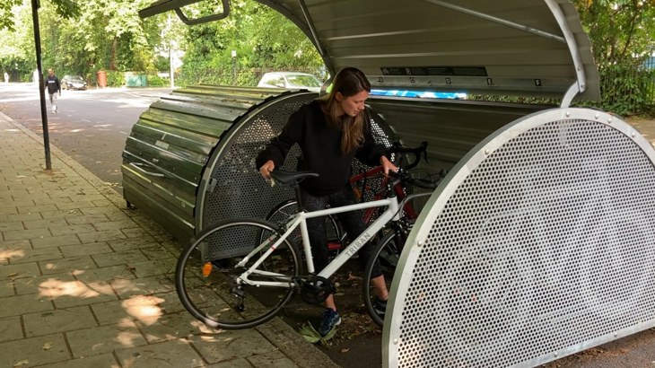 Lady putting her bike into a cycle hangar