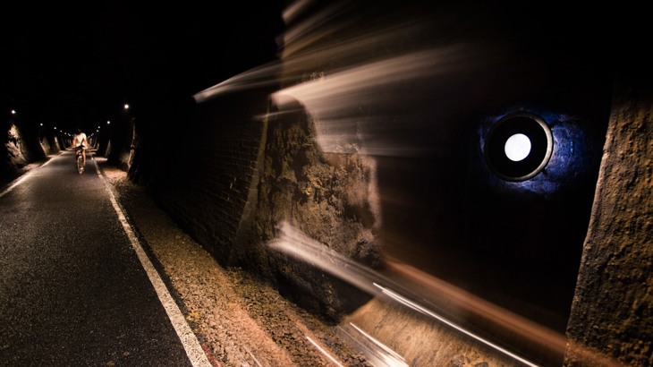 Cycle path and cyclist in lit-up tunnel