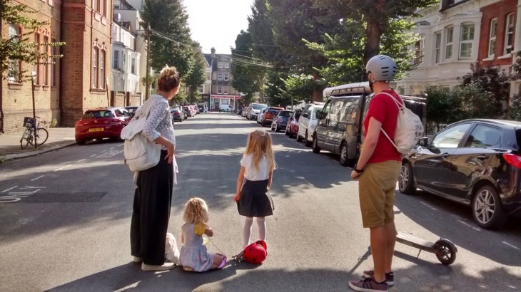 Family hang out in the middle of a road that has been closed to through traffic