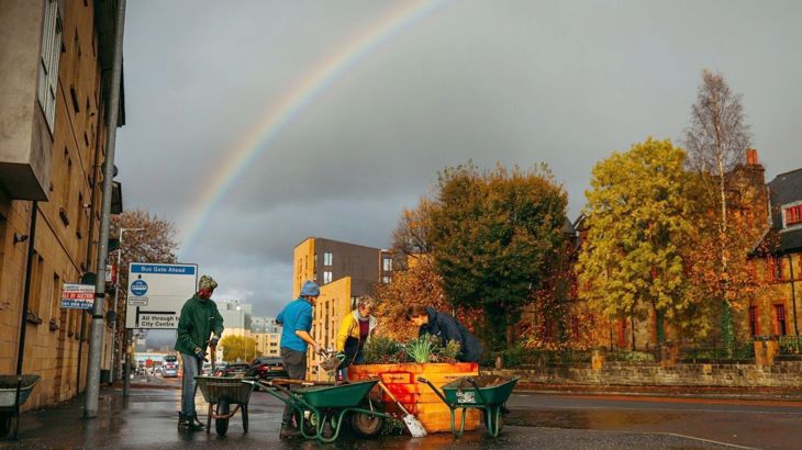Staff and volunteers from Glasgow's Hidden Garden set up planters off Victoria Road