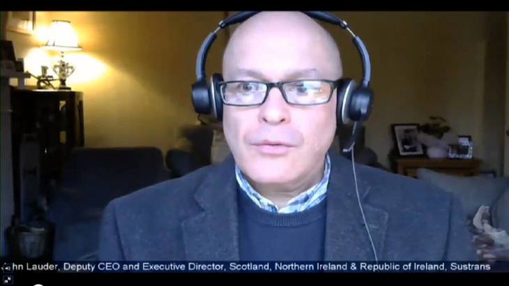 Screenshot of Walk Wheel Cycle Trust Deputy CEO, John Lauder, wearing headphones whilst talking at an online committee meeting.