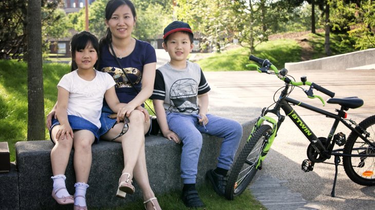 family sitting outside with a bike