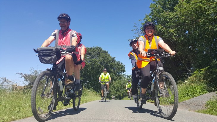 people cycling outside in the sunshine