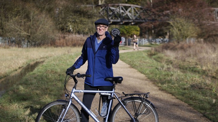 person holding oxford preservation trust award plaque and bike on traffic free shared path